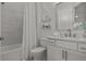 Clean bathroom with marble tile, a shower/tub combo, and floating shelves at 11449 Owasee Trails Pl, Riverview, FL 33569