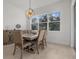 Bright dining room features a wood table and six chairs, overlooking the backyard at 11449 Owasee Trails Pl, Riverview, FL 33569
