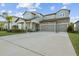 Two-story house with three-car garage and a well-manicured front yard at 11449 Owasee Trails Pl, Riverview, FL 33569