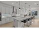 Modern kitchen with white cabinets, quartz countertops, and island with seating at 11449 Owasee Trails Pl, Riverview, FL 33569