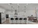 Modern kitchen with white cabinets, quartz countertops, and island with seating at 11449 Owasee Trails Pl, Riverview, FL 33569