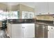 Kitchen boasts white cabinets, granite countertops, and a stainless steel dishwasher at 5352 Camberlea Ave, Zephyrhills, FL 33541