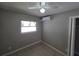 Clean bedroom with tile floors, a window, and modern air conditioning unit at 3967 Arkansas Ne Ave, St Petersburg, FL 33703