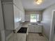 Clean, all-white kitchen with a stainless steel sink and white countertop at 3967 Arkansas Ne Ave, St Petersburg, FL 33703