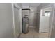A compact utility area with water heater, shelving and tile flooring at 3967 Arkansas Ne Ave, St Petersburg, FL 33703