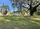 Lush backyard featuring a side view of the house, mature trees, and greenery at 750 Charlie Taylor Rd, Plant City, FL 33566