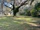 Expansive backyard featuring mature trees and side view of the home at 750 Charlie Taylor Rd, Plant City, FL 33566
