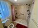 Bathroom featuring a step-in shower and toilet at 1415 Doolittle Ln # 107, Dunedin, FL 34698