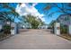 Gated community entrance with lush landscaping, brick paved road, and secure access at 2311 W Morrison Ave # 13, Tampa, FL 33629