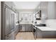 Modern kitchen featuring stainless steel appliances, gray cabinets, and bright natural light from plantation shutters at 2311 W Morrison Ave # 13, Tampa, FL 33629