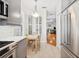 Well-lit kitchen with stainless steel appliances, gray cabinets, and breakfast nook adjacent to a spacious living area at 2311 W Morrison Ave # 13, Tampa, FL 33629