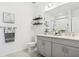 Modern bathroom with dual sinks, gray cabinets, floating shelves, and a glass-enclosed shower at 11658 Bluestone Ct, Parrish, FL 34219