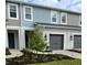 Charming two-story townhome featuring a gray garage door, and beautifully landscaped front yard at 11658 Bluestone Ct, Parrish, FL 34219