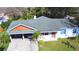 Aerial front exterior view of a home with a carport and well-maintained landscaping at 1413 May St, Lutz, FL 33548