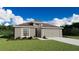 Inviting single-story home boasts a well-manicured lawn, neutral tones, and an attached two-car garage at 6080 Ballast Dr, Wimauma, FL 33598