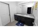 Bathroom with double sinks, dark wood cabinets, granite countertop, and a large mirror at 8680 Falling Blue Pl, Riverview, FL 33578