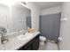 Bright bathroom featuring a single sink vanity with granite countertops and shower with curtain at 8680 Falling Blue Pl, Riverview, FL 33578