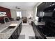 Open kitchen with granite countertops, dark cabinets, and sleek appliances, seamlessly connecting to the living area at 8680 Falling Blue Pl, Riverview, FL 33578