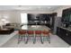 Modern kitchen featuring dark wood cabinets, granite countertops, stainless steel appliances, and a large island with bar seating at 8680 Falling Blue Pl, Riverview, FL 33578