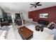 Open-concept living room with a dark accent wall, white sofas, wood coffee table, and a view into the modern kitchen at 8680 Falling Blue Pl, Riverview, FL 33578