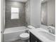 Well-lit bathroom featuring a single sink vanity and shower-tub combo with gray tile at 6925 161St E Ter, Parrish, FL 34219