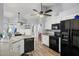 Kitchen with black appliances, wood floors, and ceiling fan at 6929 Northlake Dr, Zephyrhills, FL 33542