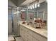 Bathroom featuring a double sink vanity, soft pink decor and a shower stall with glass doors at 8623 Snowy Owl Way, Tampa, FL 33647