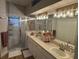 Bathroom featuring a double sink vanity, soft pink decor, wood floors and a shower stall with glass doors at 8623 Snowy Owl Way, Tampa, FL 33647