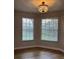 Bedroom featuring two windows with blinds and chandelier at 8623 Snowy Owl Way, Tampa, FL 33647