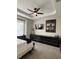 Comfortable bedroom featuring neutral walls, tray ceiling and fan, carpet and a large dresser at 8623 Snowy Owl Way, Tampa, FL 33647