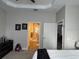 Comfortable bedroom featuring neutral walls, tray ceiling and fan, carpet and a bathroom entrance at 8623 Snowy Owl Way, Tampa, FL 33647