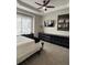 Comfortable bedroom featuring neutral walls, tray ceiling and fan, carpet and a long dresser at 8623 Snowy Owl Way, Tampa, FL 33647