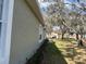 View of landscaped side yard with exterior of home on a sunny day at 8623 Snowy Owl Way, Tampa, FL 33647