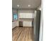 Bright kitchen with stainless steel dishwasher, white cabinets, and view of living room at 8623 Snowy Owl Way, Tampa, FL 33647