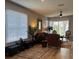 Open-concept living room featuring hardwood floors, comfortable seating, and lots of natural light at 8623 Snowy Owl Way, Tampa, FL 33647