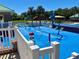 A vibrant splash pad with colorful water features, lounge chairs, and a secure white fence at 8623 Snowy Owl Way, Tampa, FL 33647