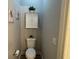 Neutral-toned bathroom featuring a toilet with a storage cabinet above and simple decorative art on the surrounding walls at 8623 Snowy Owl Way, Tampa, FL 33647
