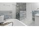 Bright bathroom featuring a modern tub, glass shower, and stylish blue-gray tiling at 6421 Santa Monica Dr, Tampa, FL 33615