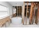 Bathroom featuring a modern soaking tub, with a window for natural light and open framing for a custom design at 6805 Holmes Blvd, Holmes Beach, FL 34217