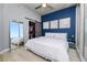 Bedroom with bright blue accent wall, white bedding, sliding closet doors and city view at 777 N Ashley Dr # 2313, Tampa, FL 33602