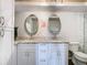 Modern bathroom with double sinks, granite counters, and white cabinets at 5509 Pilots Pl, New Port Richey, FL 34652