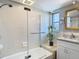 Bathroom showing a tub, tile shower and a double granite vanity with modern fixtures at 5509 Pilots Pl, New Port Richey, FL 34652