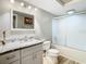 Bathroom featuring granite vanity, modern fixtures, and glass-enclosed shower/tub at 5509 Pilots Pl, New Port Richey, FL 34652