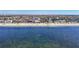 Scenic beach view with calm, azure waters and a community of homes nearby at 5509 Pilots Pl, New Port Richey, FL 34652
