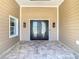 Inviting front porch featuring double doors with decorative glass, sconce lighting, and stone tile flooring at 5509 Pilots Pl, New Port Richey, FL 34652
