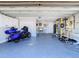 Spacious garage with painted floors, white cabinets, and gym equipment at 5509 Pilots Pl, New Port Richey, FL 34652