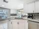 Bright kitchen showcases granite counters, white cabinetry, and stainless steel appliances at 5509 Pilots Pl, New Port Richey, FL 34652