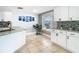Bright kitchen features a white cabinetry, granite countertops, and tile backsplash at 5509 Pilots Pl, New Port Richey, FL 34652