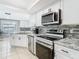 Well-equipped kitchen with stainless steel appliances and granite countertops at 5509 Pilots Pl, New Port Richey, FL 34652