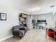 The living room features wood flooring, a bookshelf, and a comfortable chair at 5509 Pilots Pl, New Port Richey, FL 34652